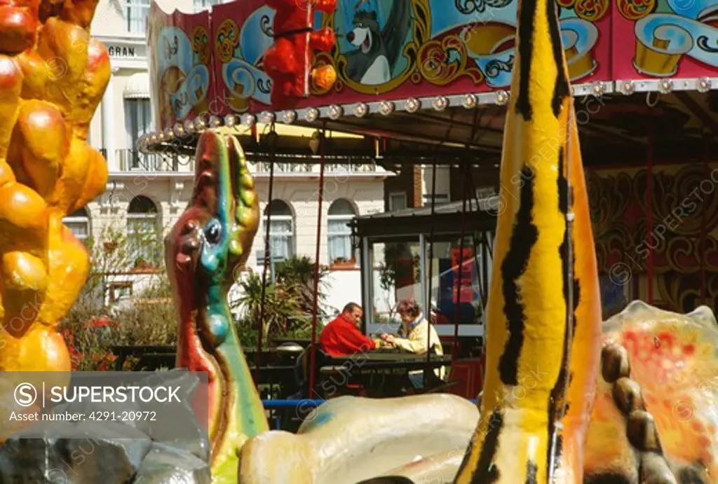 Middleaged couple seen through colourful fairground figures