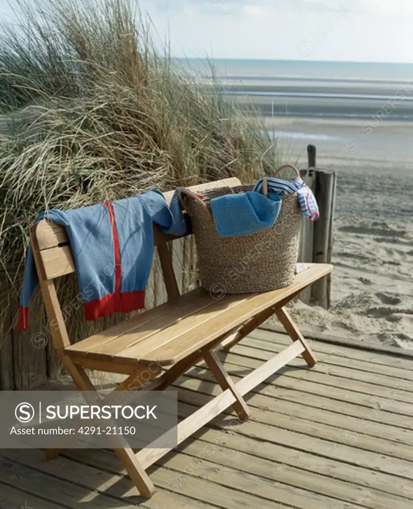 Basket of cloths on decking beside large beach