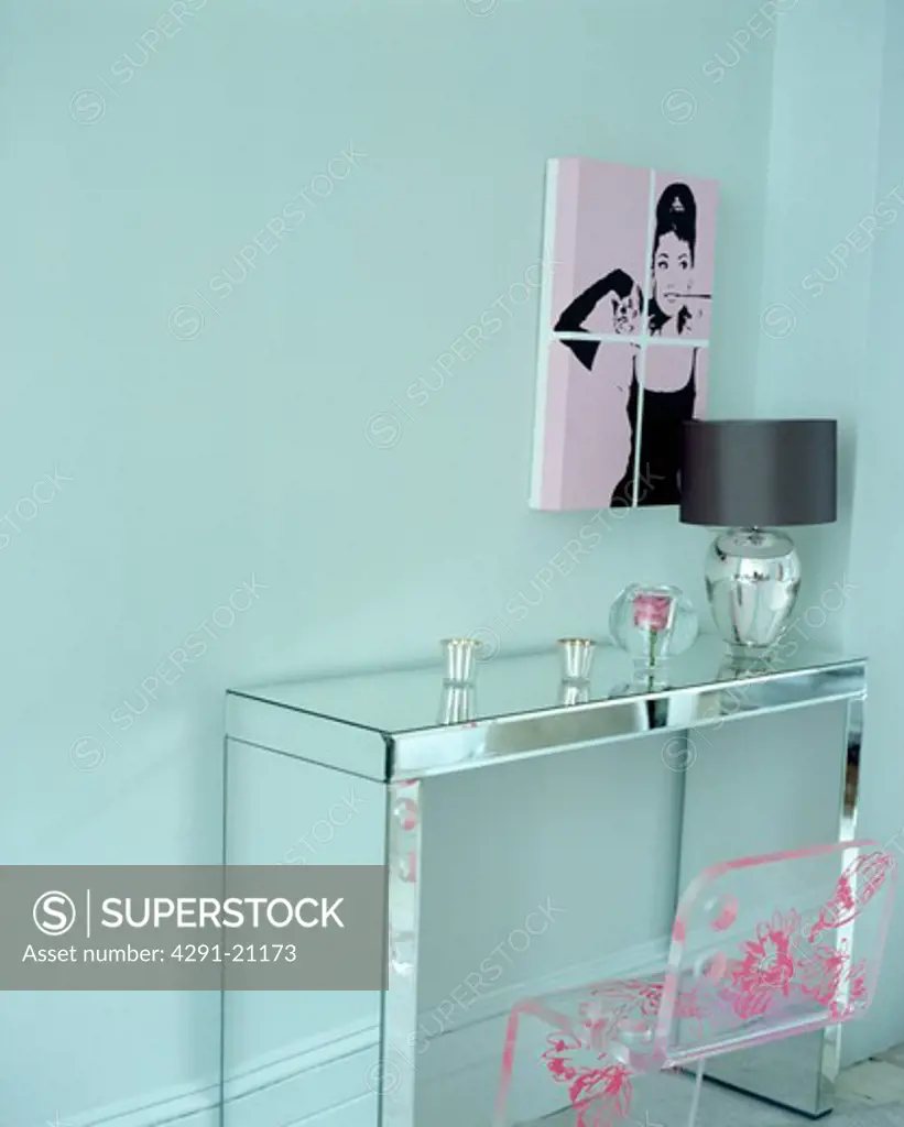 Audrey Hepburn picture on turquoise wall above mirrored table with perspex chair