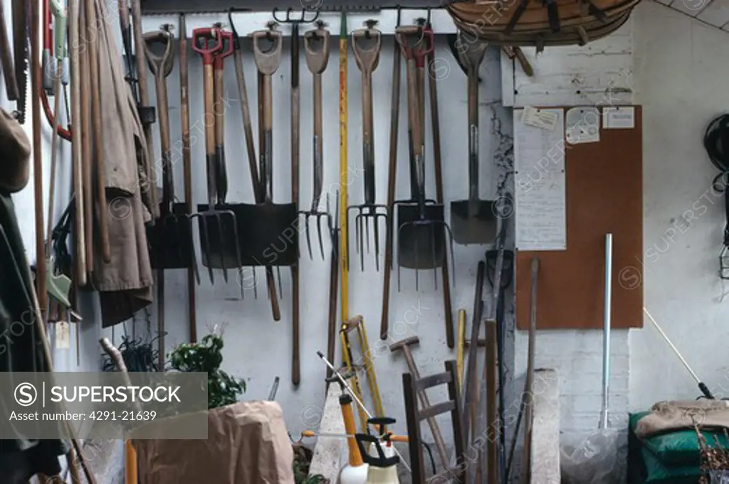Garden tools stored on pegs in potting shed