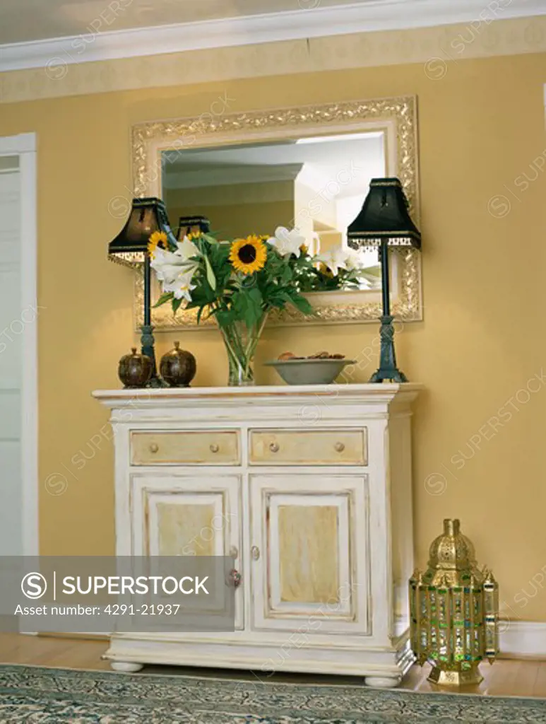 Black lamps on painted cream cupboard in neutral hall