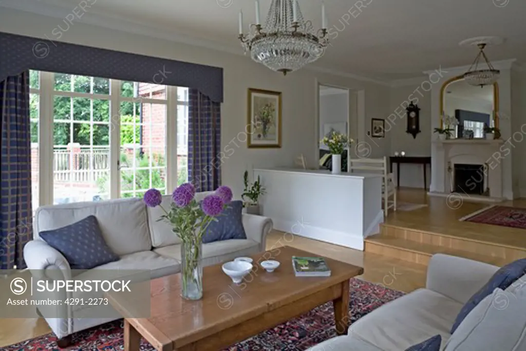 Cream sofas and wooden table in airy country living room