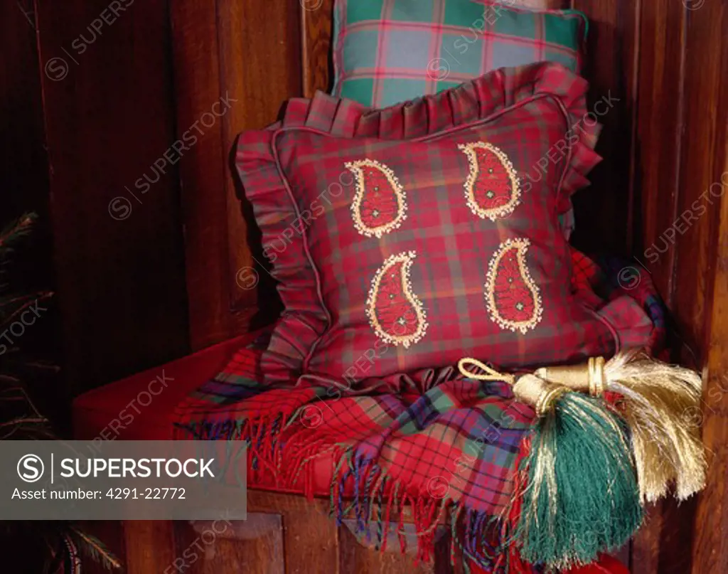 Close-up of red tartan cushion with appliqued Paisley design