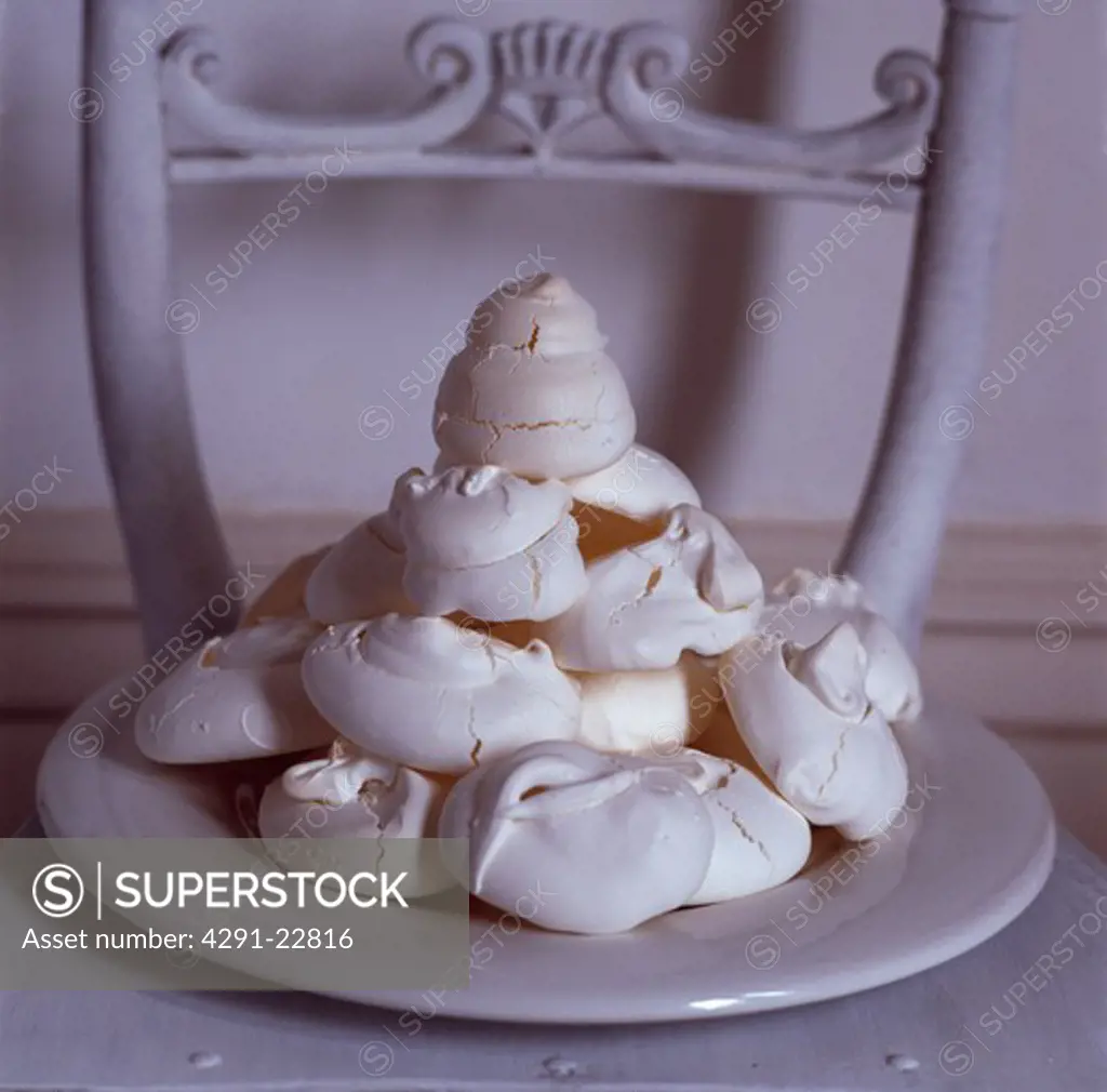 Detail shot of a plate of meringues on a white painted chair