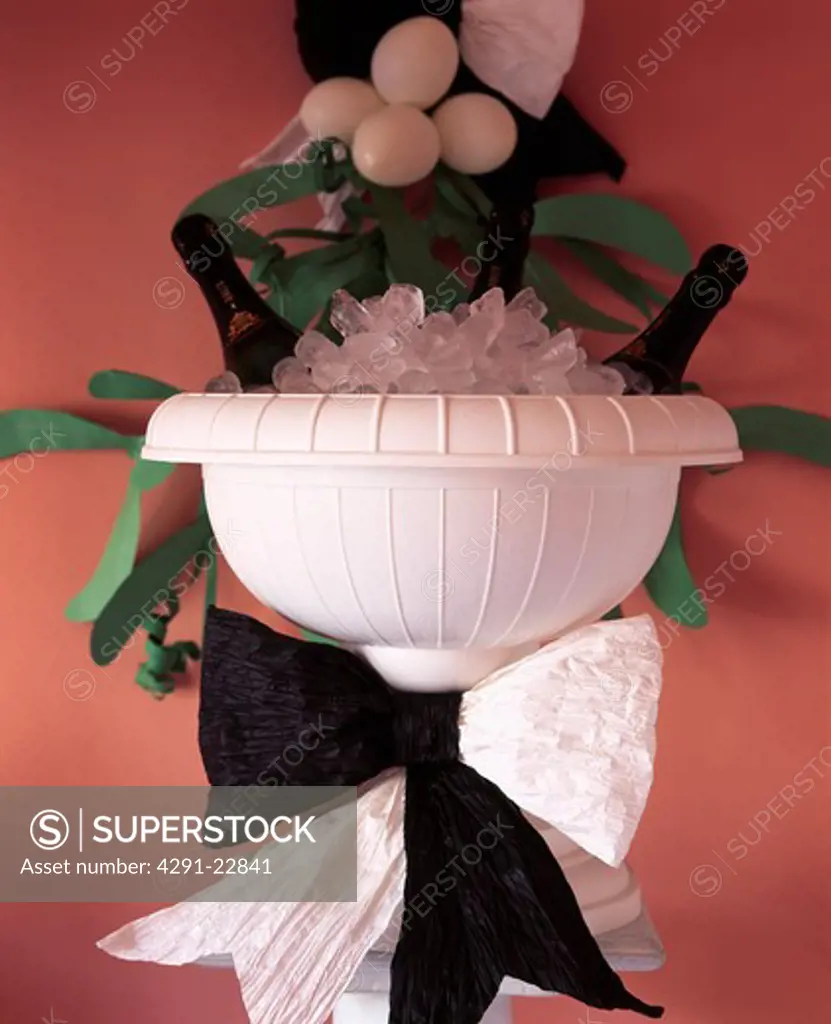 Close-up of white urn-shaped ice bowl decorated with black and white paper ribbon