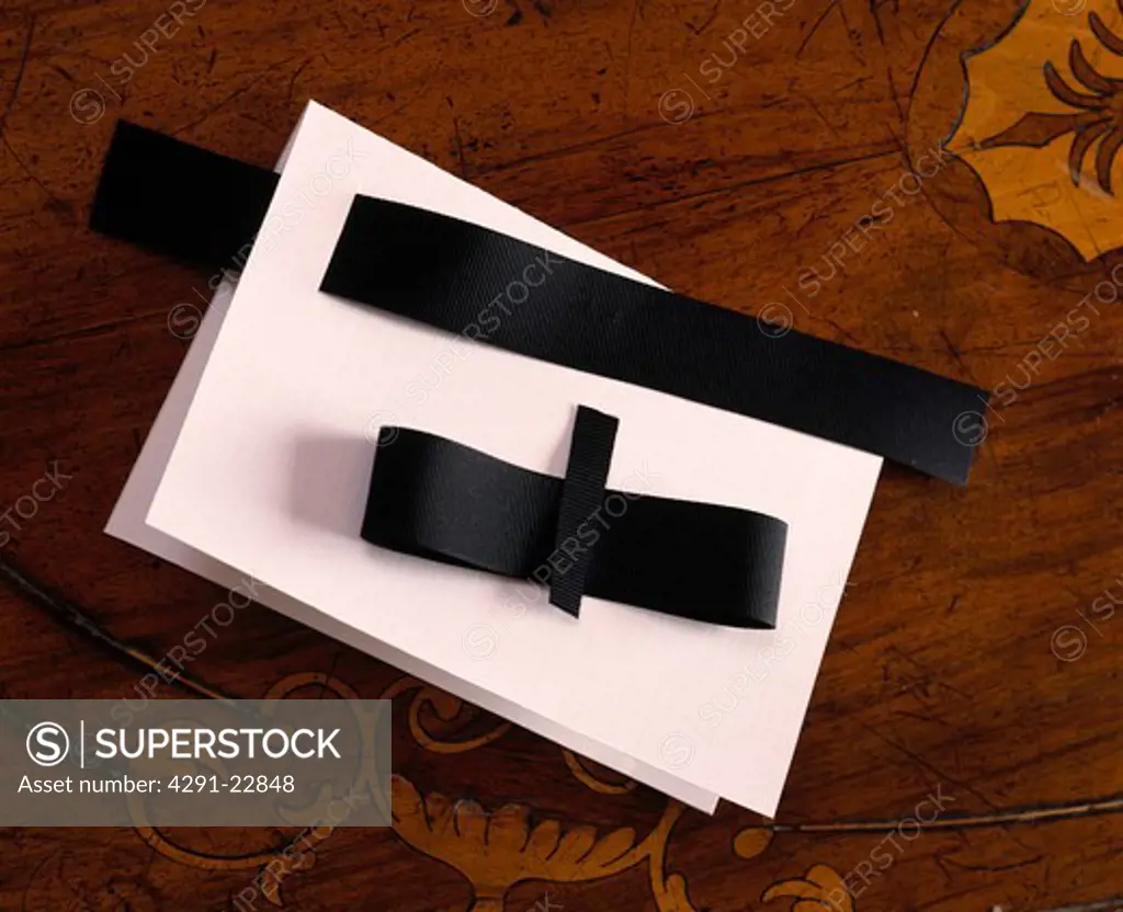 Close-up of card to make party invitation in the shape of black bow-tie and white shirt