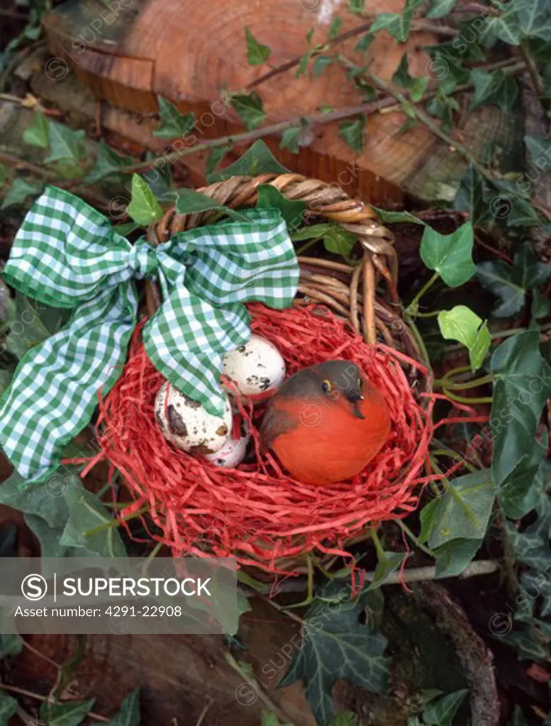 Close-up of felt robin with eggs in basket tied with green checked ribbon