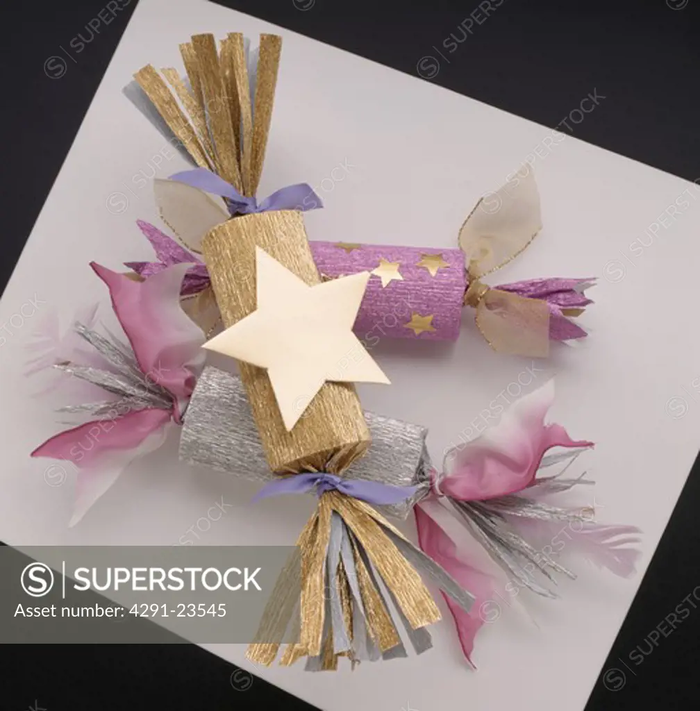 Close-up of gold and purple crepe paper Christmas crackers with gold star decoration