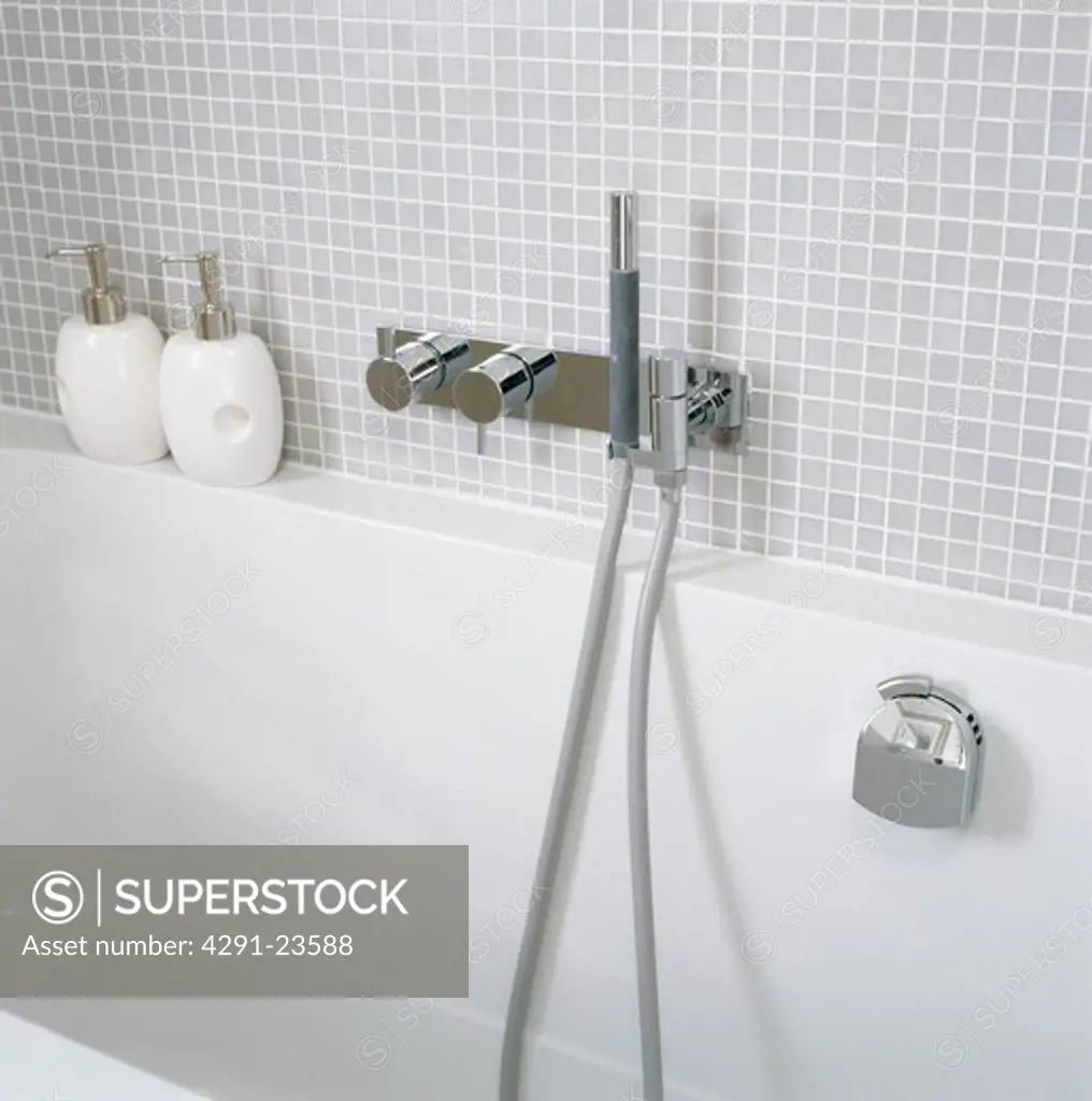 Modern white bath with chrome showerhead and taps