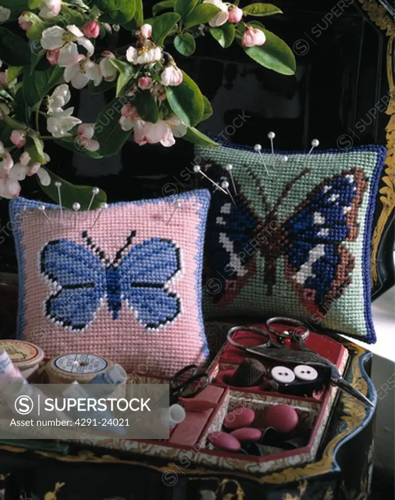 Close-up of butterfly motif cross-stitch cushions