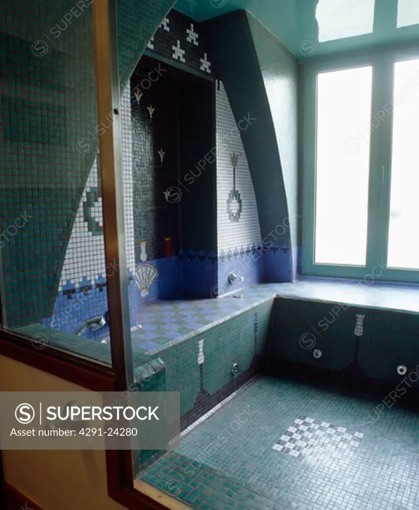 Turquoise blue and white patterned mosaic tiled wall above sunken mosaic bath in Moorish-style bathroom