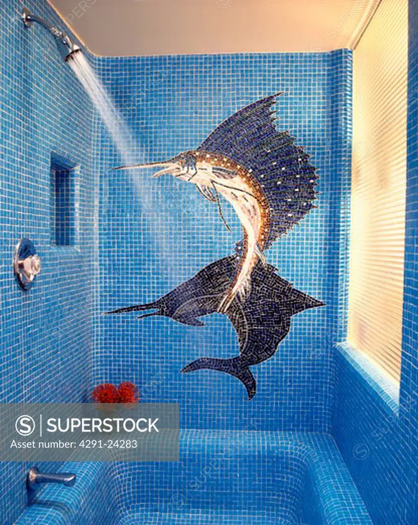 Large fish mosaic mural on blue mosaic shower room walls with water pouring from shower head