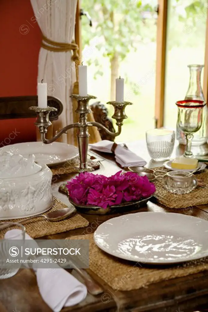 Close-up of table set with white plates and linen table napkins with candelabra