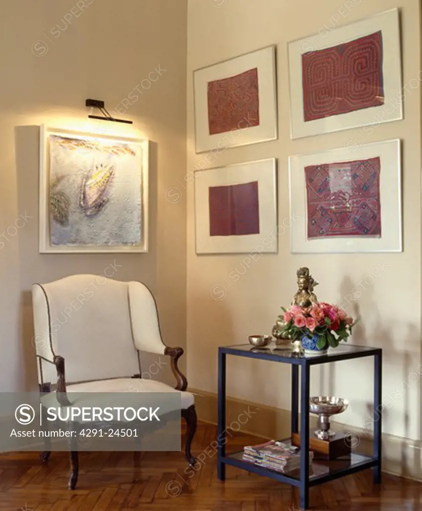 Group of pictures on wall in traditional living room with white chair