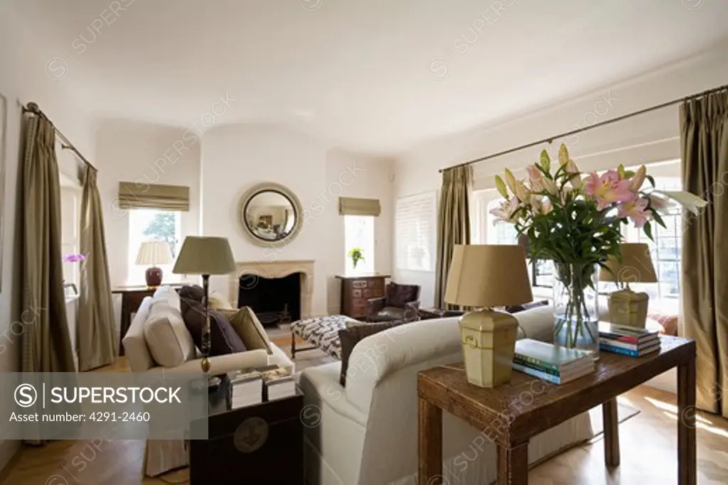 Antique table behind cream sofa in cream country living room
