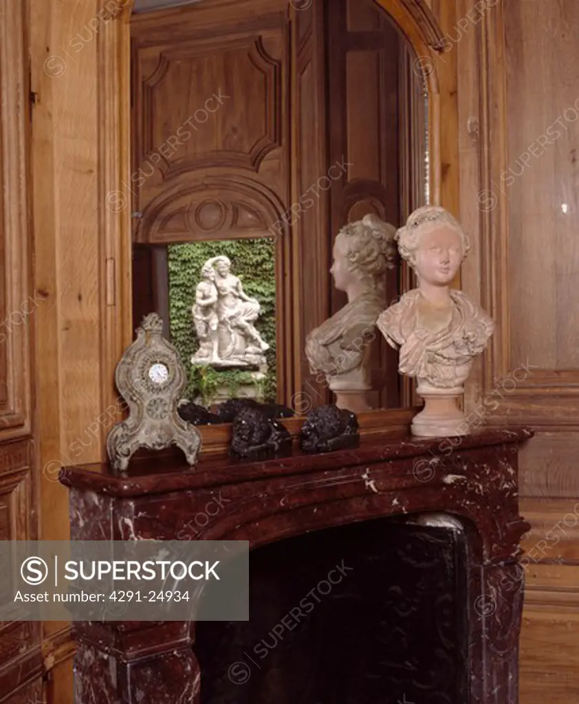 Close-up of mirror above classical bust on mantelpiece
