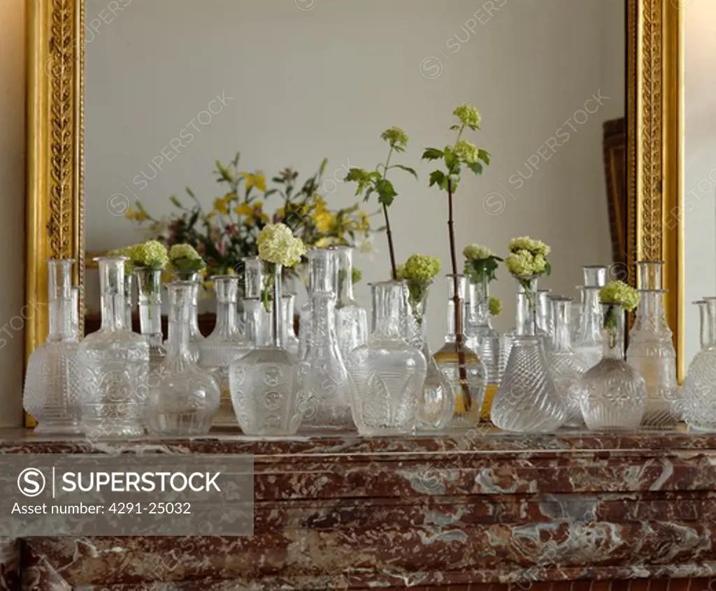 Close-up of antique pressed-glass decanters on mantelpiece