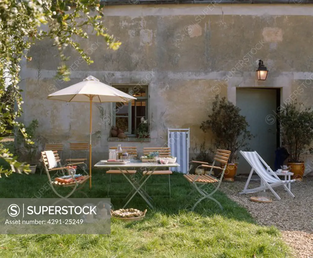 Parasol with chairs and table French garden in summer