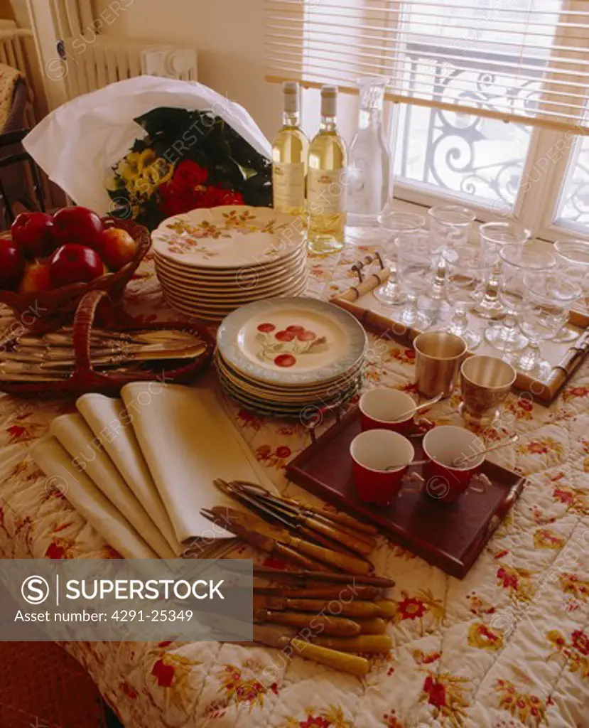 Close-up of table set for tea with antique cutlery and floral tablecloth