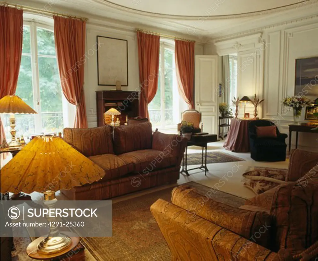 Lighted lamps and cvomfortable sofas in country drawing room