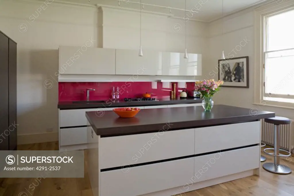 Island unit with cast concrete resin worktop in modern kitchen with white gloss lacquer units