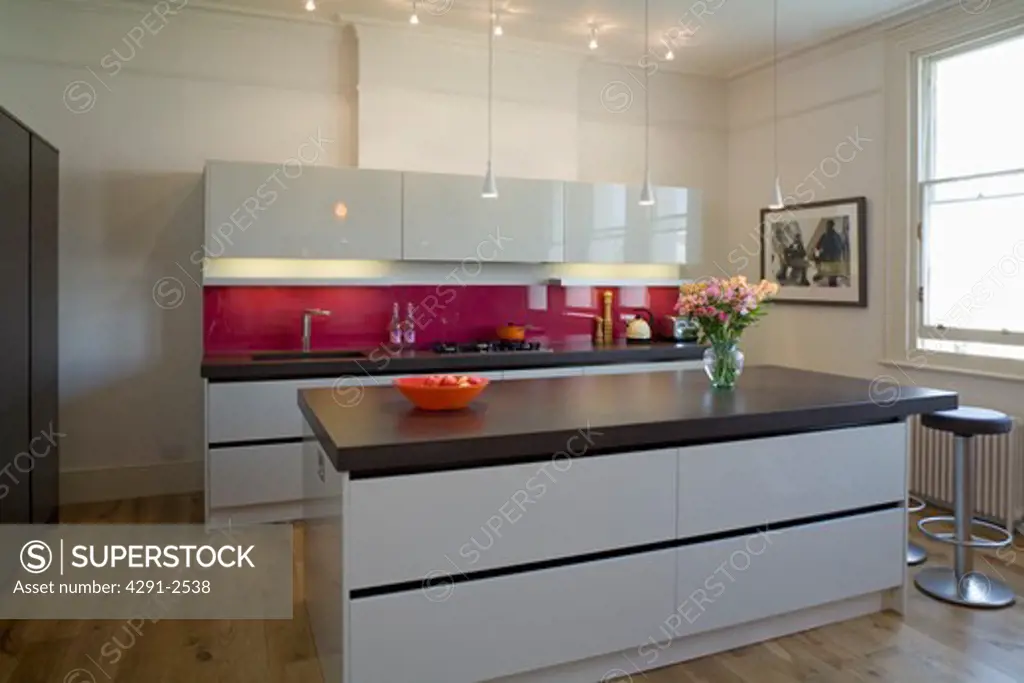 Island unit with cast concrete resin worktop in modern kitchen with white gloss lacquer units