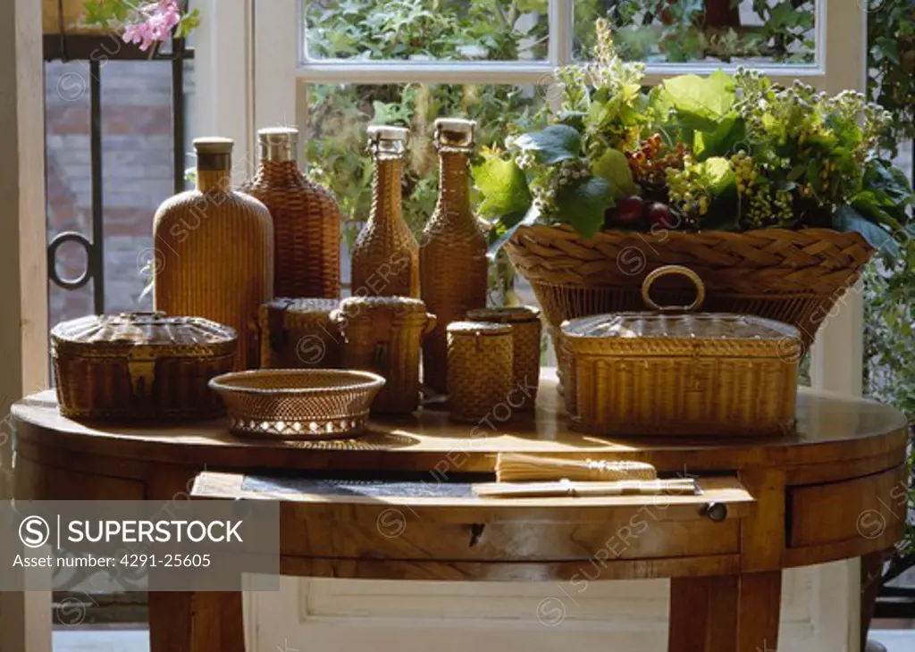 Close-up of wicker bottles and baskets on antique table