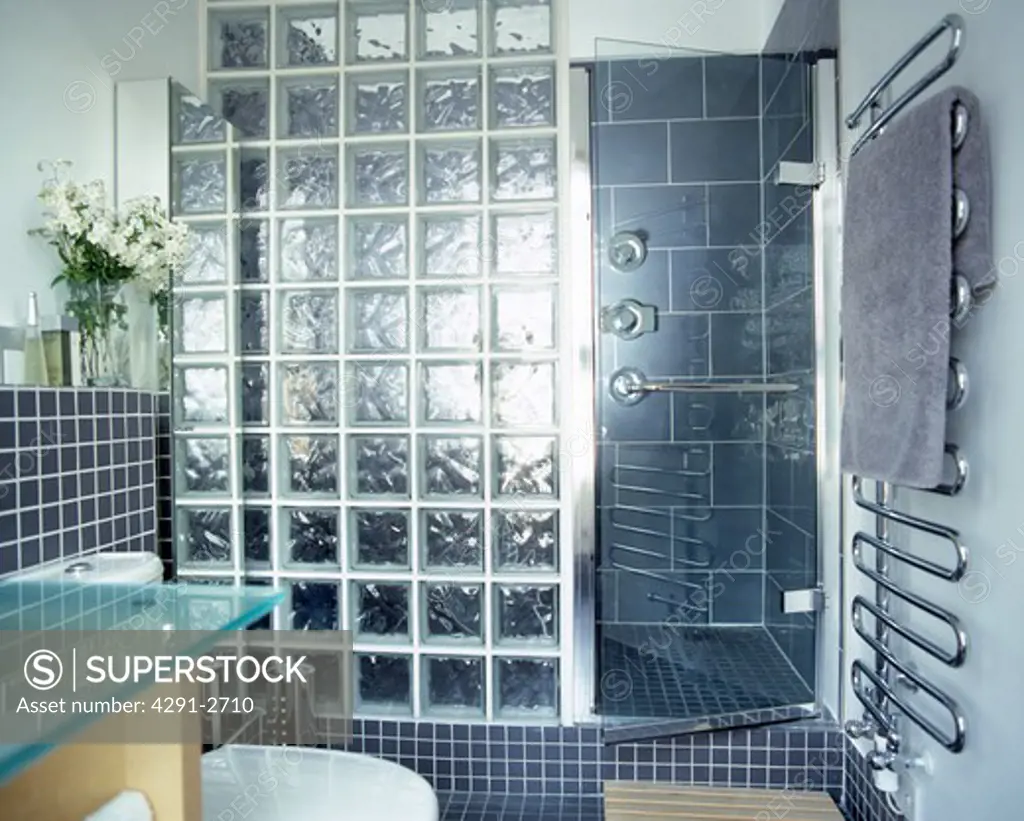 Fully tiled grey bathroom with glass brick shower screen