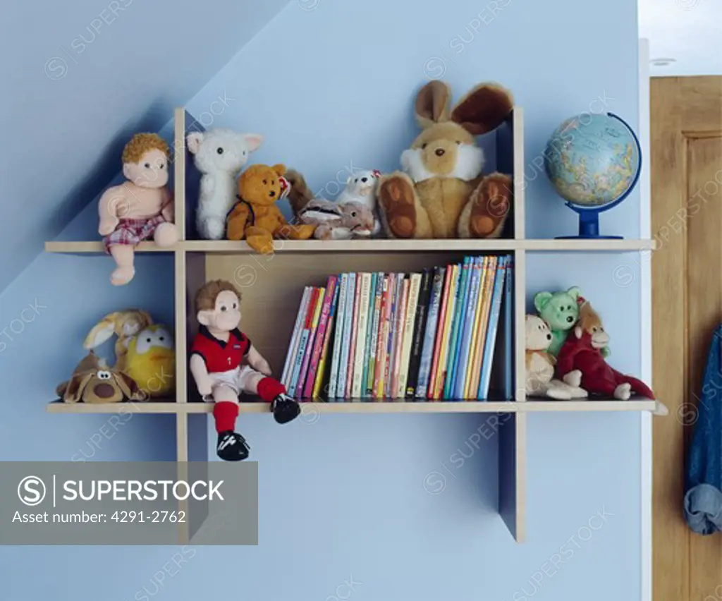Children's books and toys on shelves in a blue attic bedroom