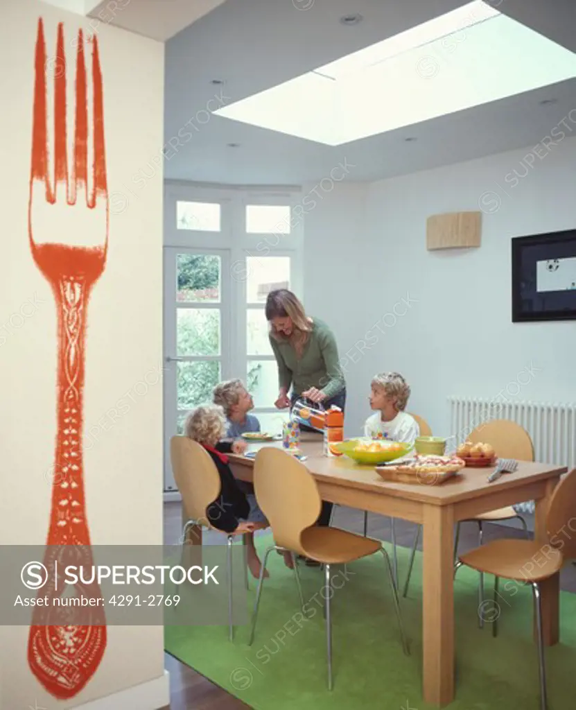 Mother and children at table in modern dining room extension FOR EDITORIAL USE ONLY