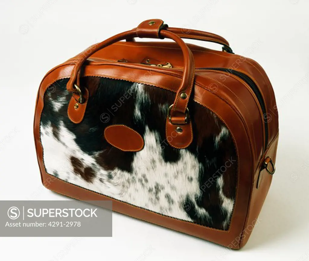 Close-up of faux animal-skin and brown leather holdall bag