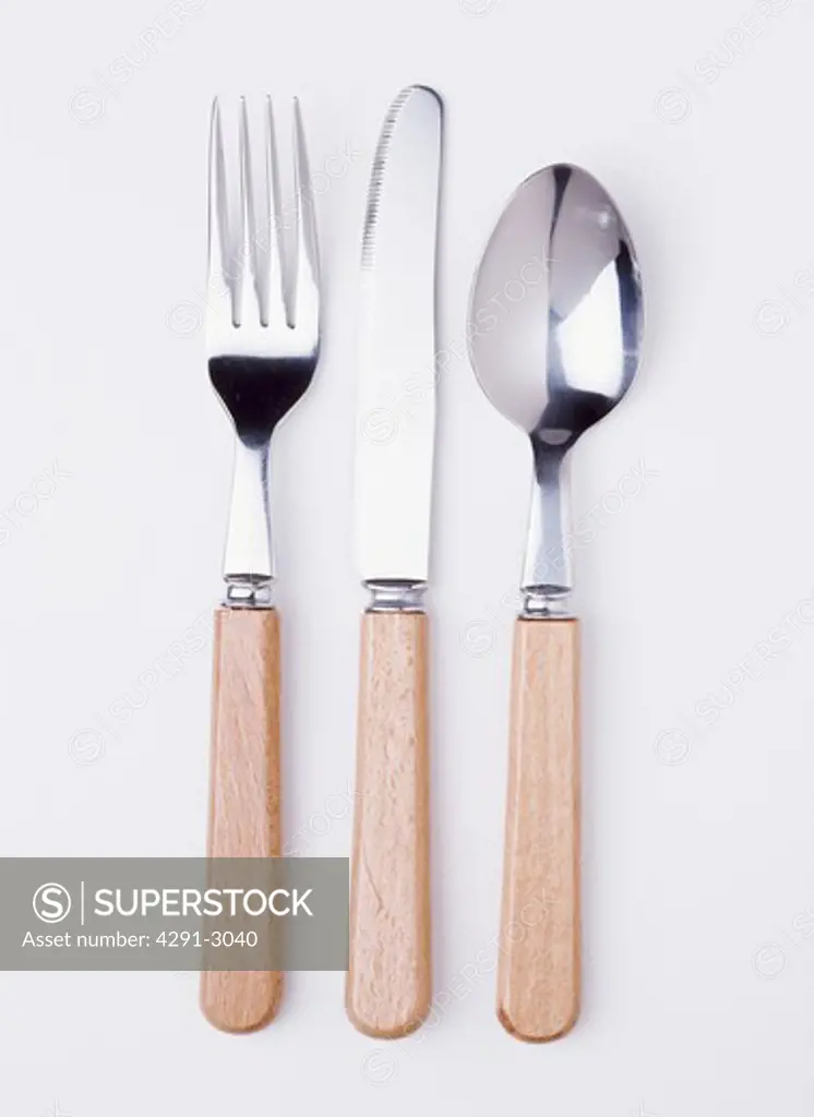 Close-up of wooden-handled knife and fork with spoon