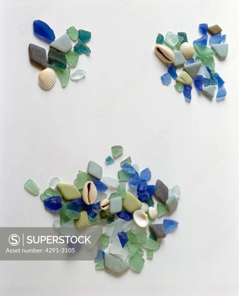 Close-up of small seashells with pieces of blue and green sea-glass