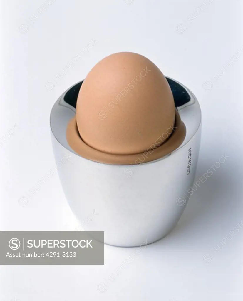 Close-up of boiled egg in modern silver egg-cup