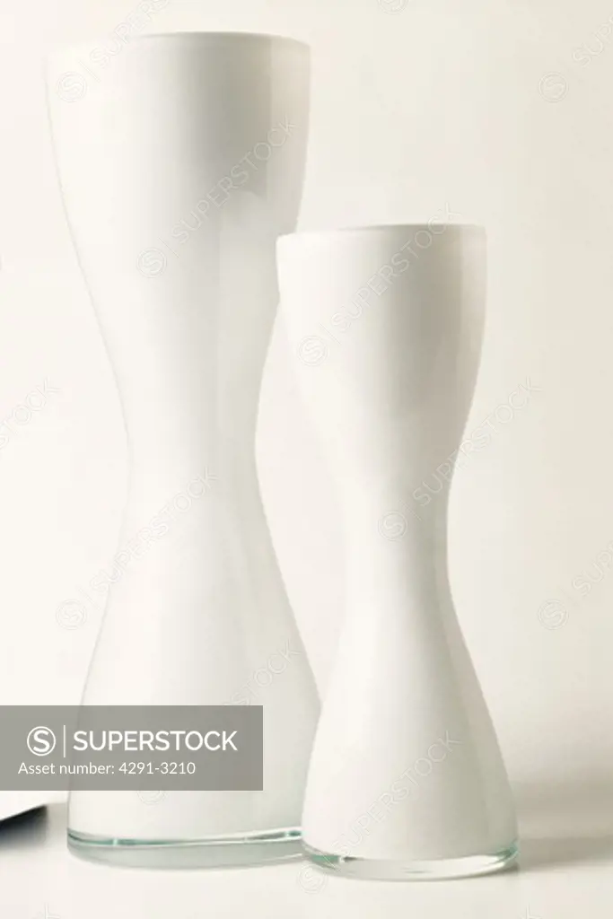 Close-up of two modern white opaque glass vases