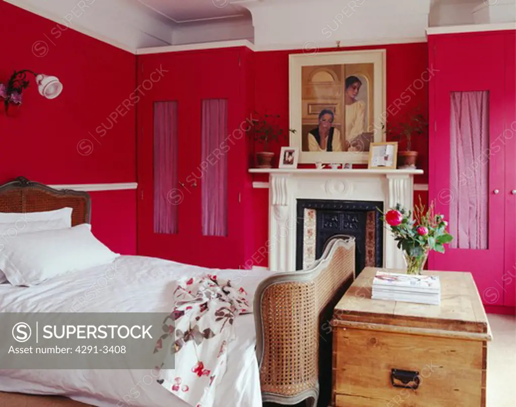Large traditional pink bedroom with period fireplace and wardrobes built into the alcoves