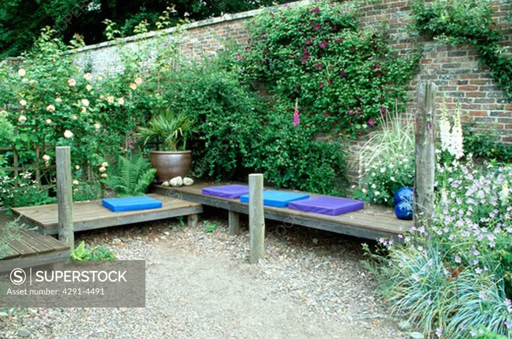 Blue cushions on wooden benches in country garden in summer