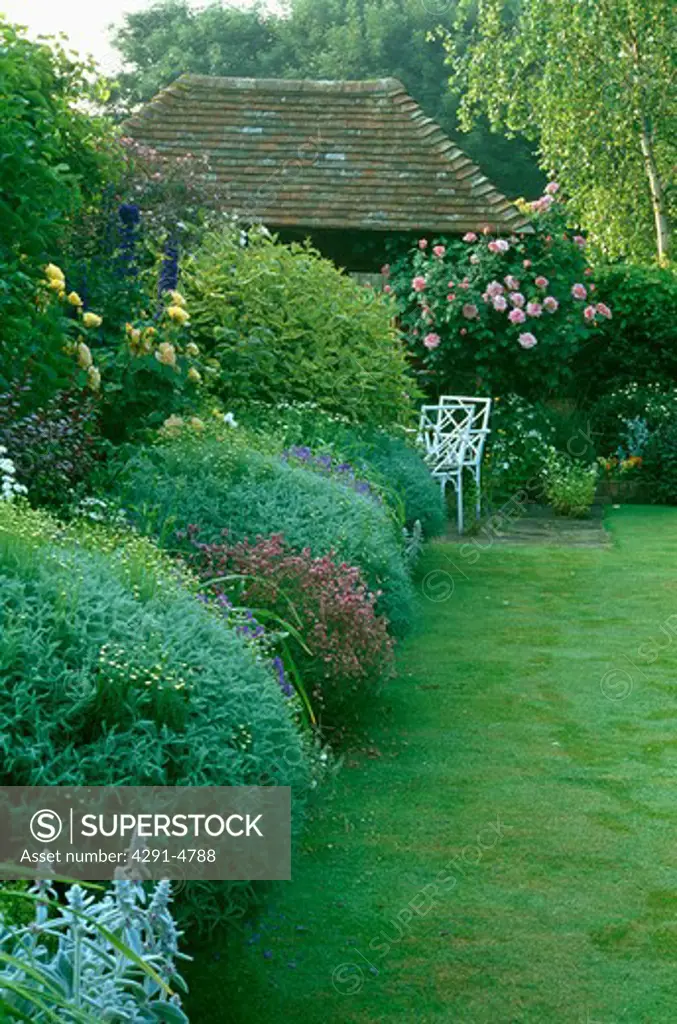 Lawn and herbaceous border in large country garden in summer