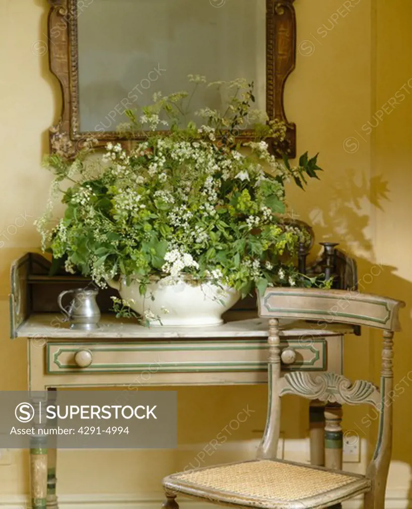 Close-up of white cow-parsley in natural flower arrangement in white dish on painted table