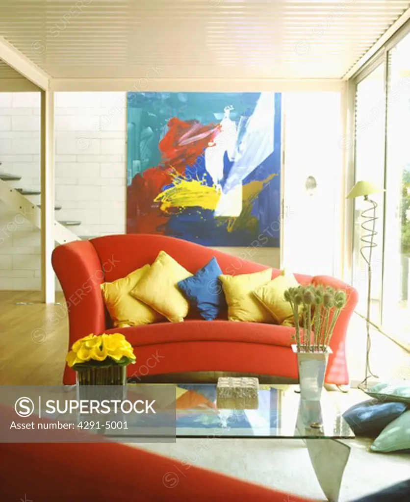 Multicoloured cushions on red sofa in modern living room