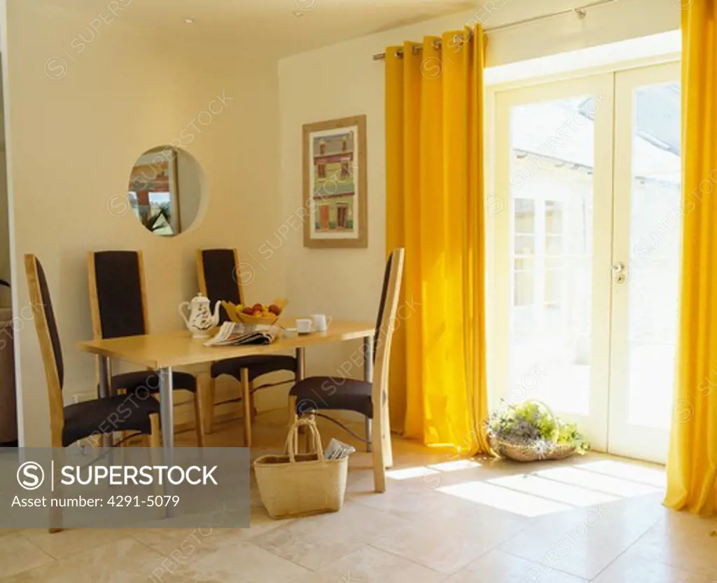 Yellow curtains and limestone flooring in modern dining room