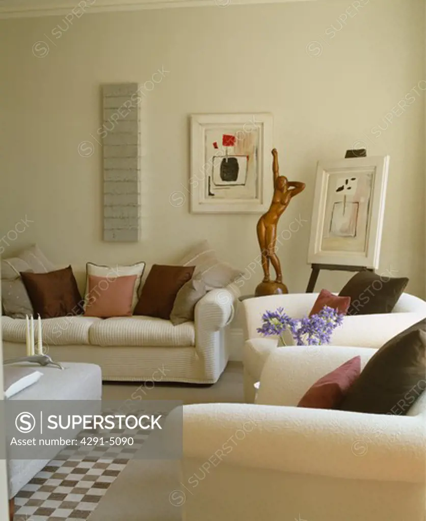 Cream sofas and bronze statue in modern cream living room