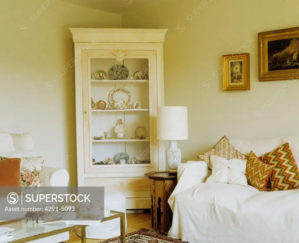 Cream corner bookcase in cream cottage living room
