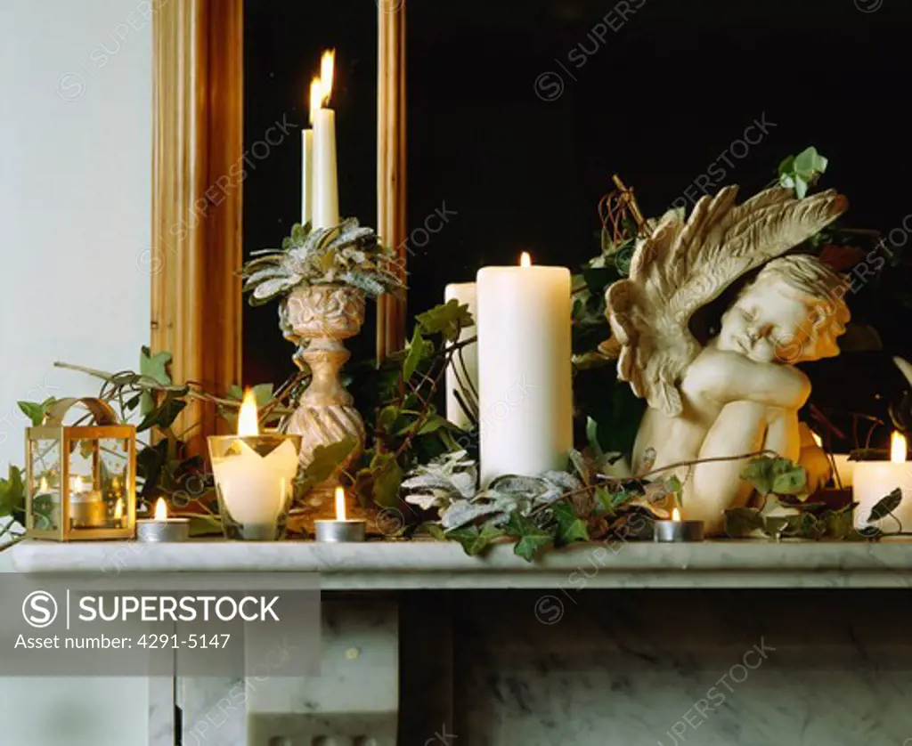 Mantlepiece decorated with candles, cherubs and ivy for Christmas