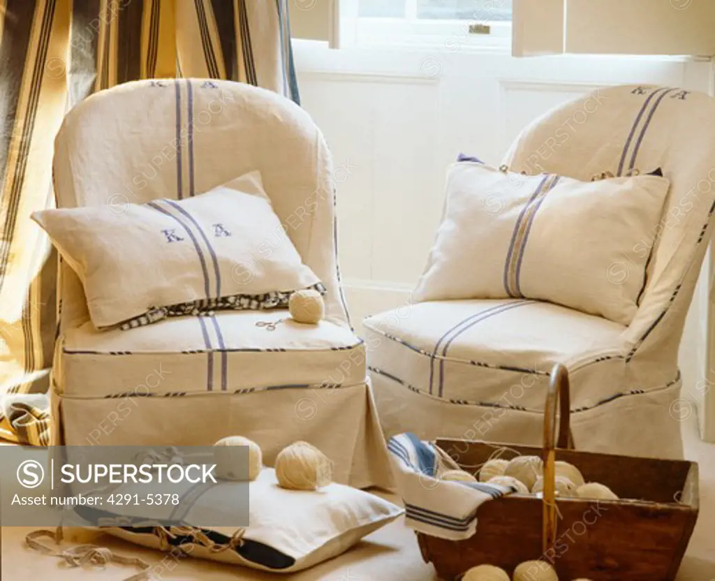 Close-up of armchairs with loose-covers and cushions made from linen tea-towels