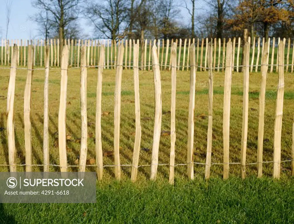 Wooden stake fence on perimeter of new garden before planting