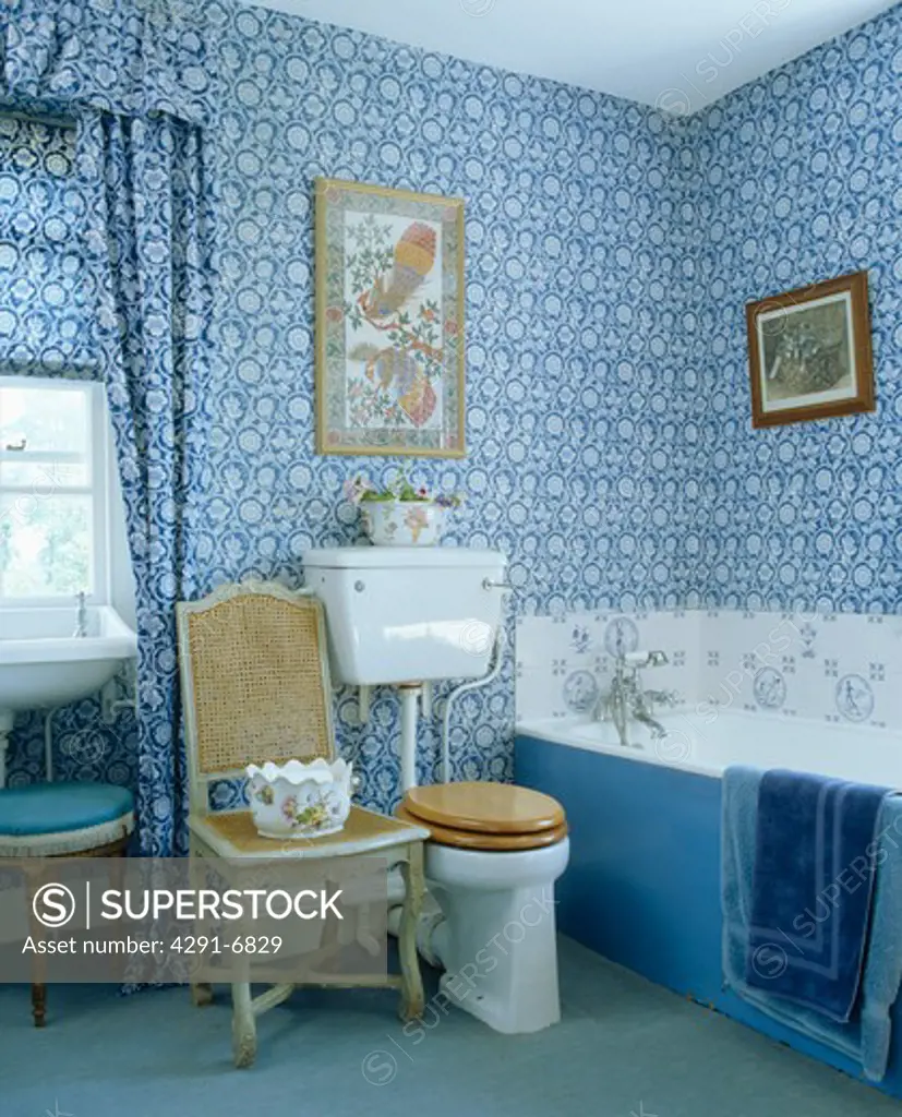 Blue and white wallpaper and matching curtains in traditional bathroom