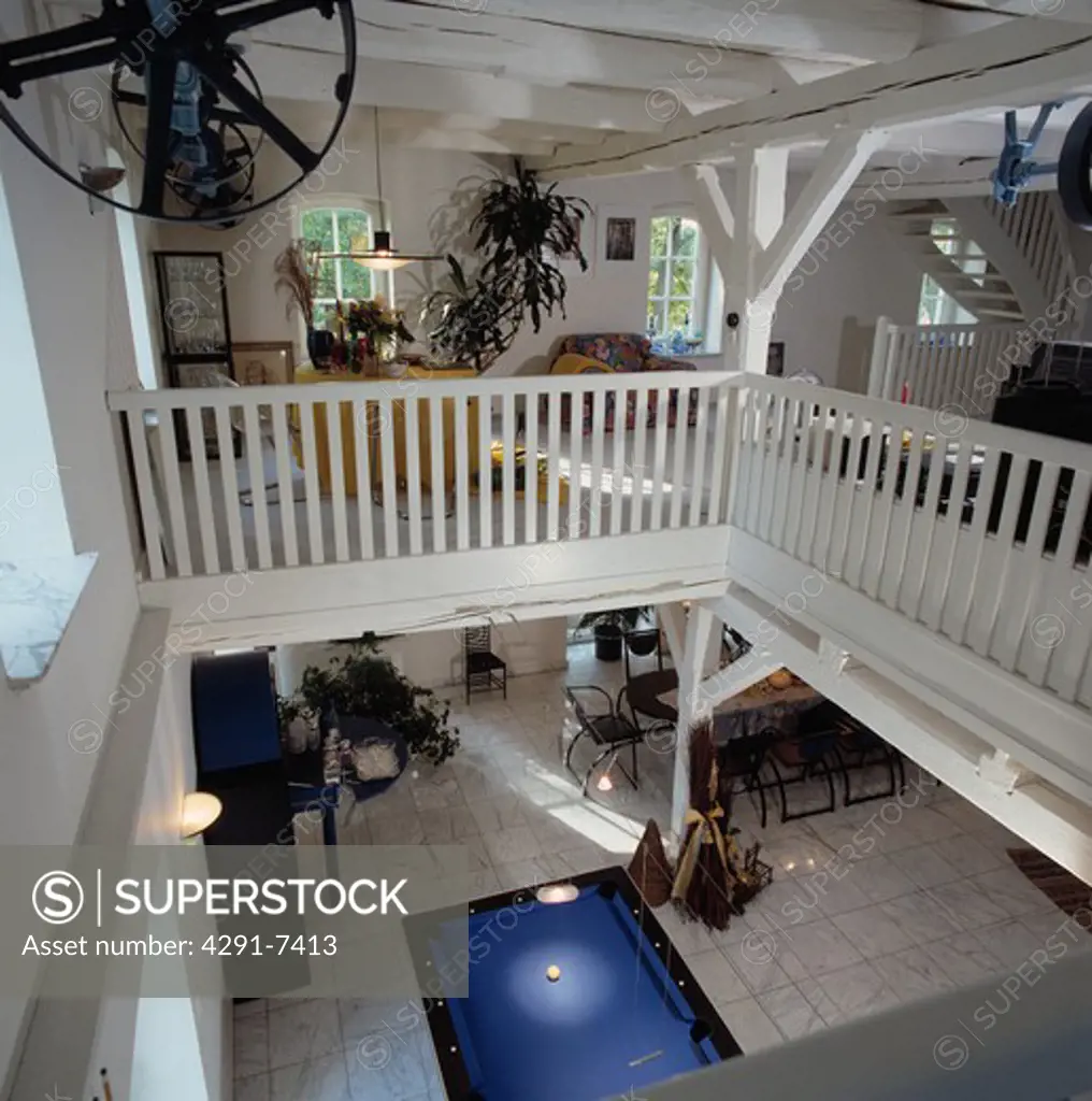 White banisters on first floor of open plan interior of converted water mill
