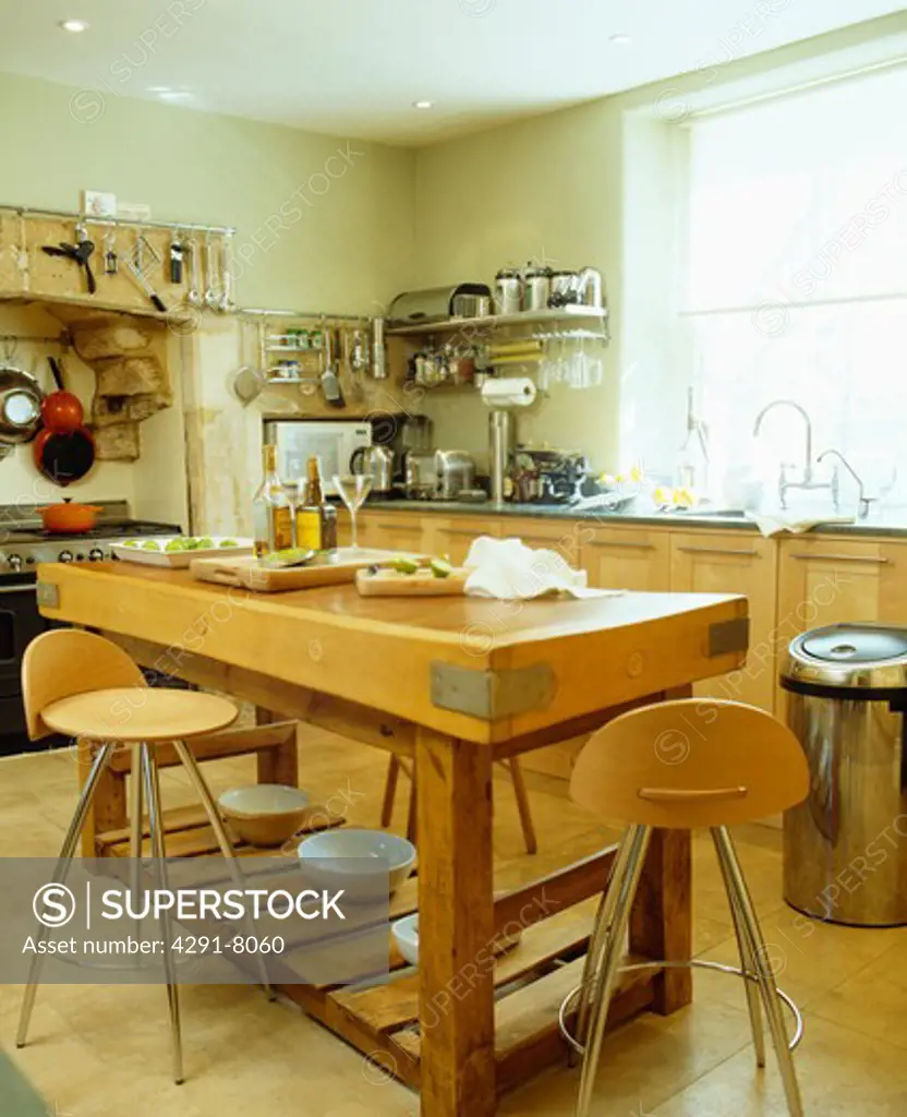Wood and steel stools at butcher's block in modern kitchen