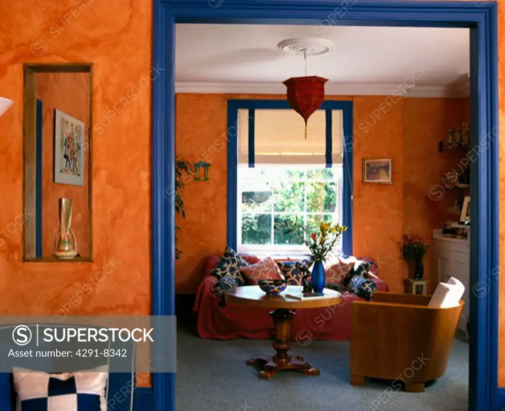 Painted sponge effect on orange walls of living room with blue paintwork